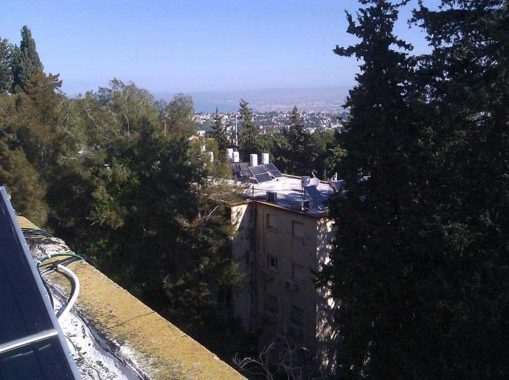 The view of the Haifa bay from the roof, other solar collectors and scary fact there is no fence to hold you from falling! =o Solar Water Heating System