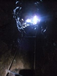 The first ladder inside the hole, with missing steps.