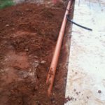 The drain pipe from the other side of the yard.