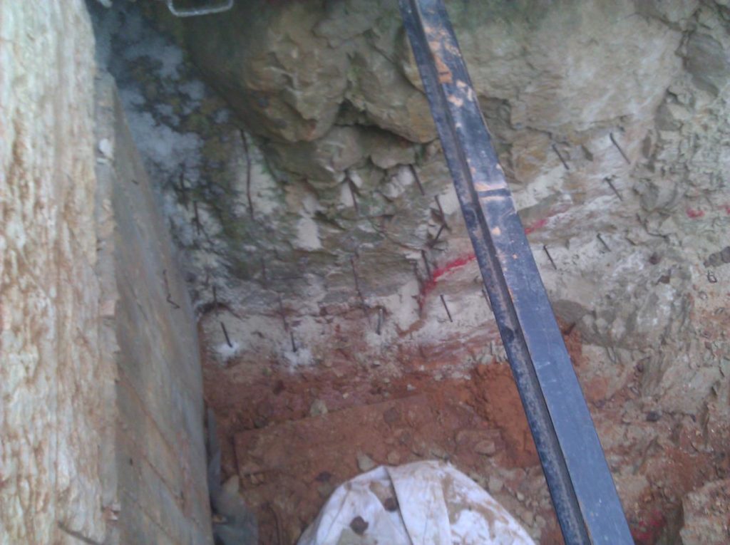 Reinforcement bars inserted into the rock to hold it and connect the rock and the concrete. - drain pipe