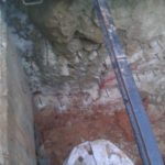 Reinforcement bars inserted into the rock to hold it and connect the rock and the concrete. - drain pipe