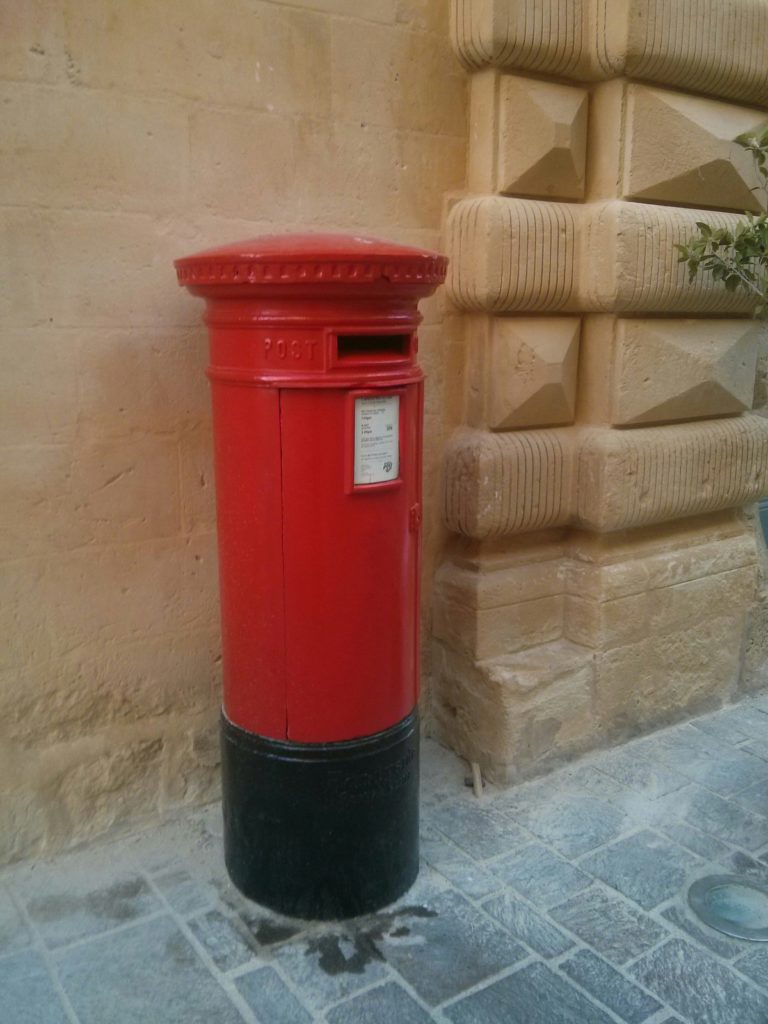 A red mailbox in the street of Valletta