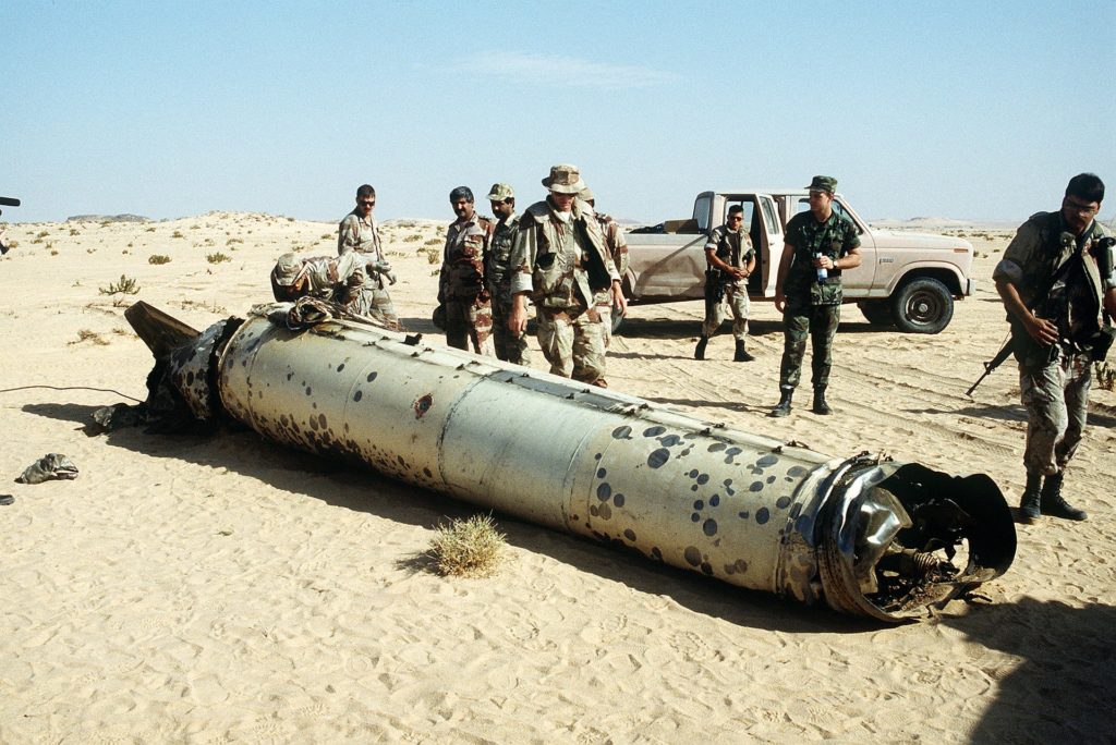 Military personnel examine the tail section of a scud missile  shot down by an-MIM 104 Patriot Air Defense Missile. (Source: Wikipedia)