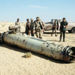 Military personnel examine the tail section of a scud missile  shot down by an-MIM 104 Patriot Air Defense Missile. (Source: Wikipedia)