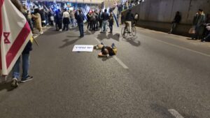 Lying on the road, the sign reads Yesh Atid (Yair Lapid Party)