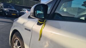 Yellow ribbon a side mirror car at the street