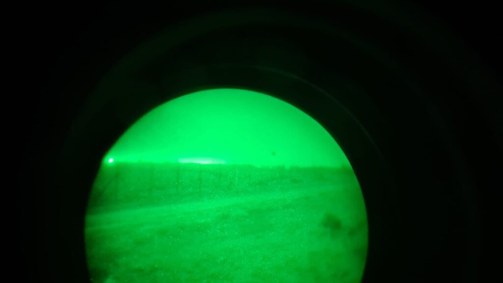 Looking on the border fence through a night vision decice - defense fighting